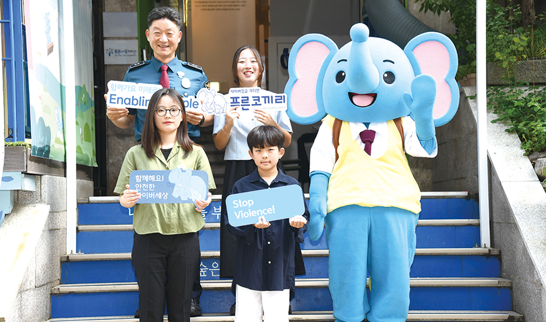 Participants posing with the Blue Elephant character during a cyber violence prevention campaign.